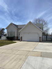 View of front of house featuring an attached garage, concrete driveway, brick siding, a gate, and RV Parking