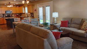 Living area with a ceiling fan, dark carpet, and recessed lighting