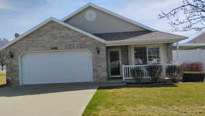 Single story home with an attached garage, driveway, a porch, brick siding, and roof with shingles