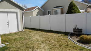Fenced yard featuring a storage unit