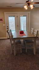Dining space with dark colored carpet and ceiling fan