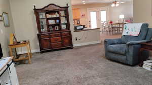 Living area with light carpet and a ceiling fan