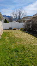 Fenced backyard featuring a mountain view