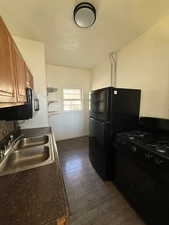 ADU Kitchen with black appliances, dark wood finished floors, and wood finish cabinets