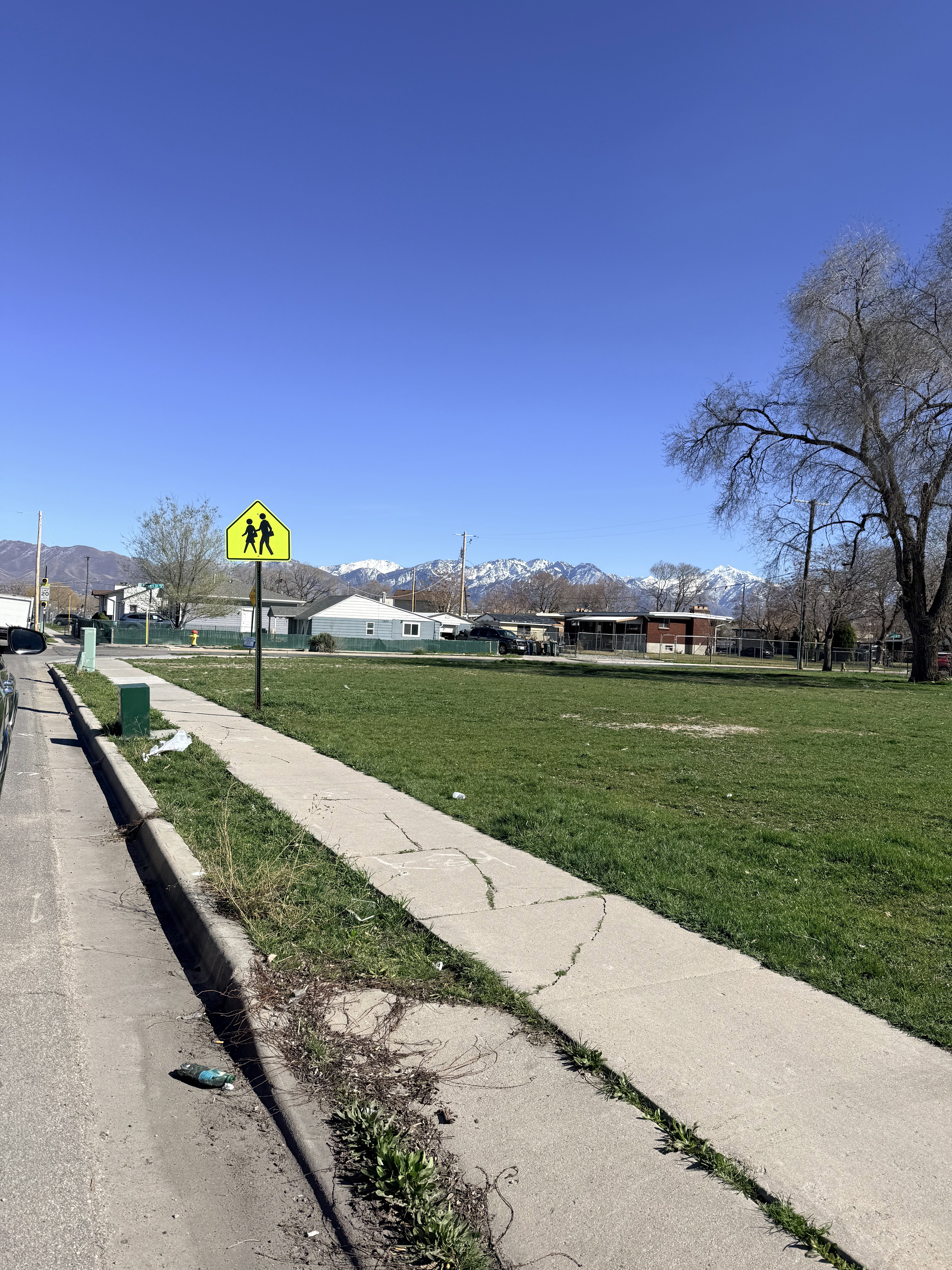 View of street featuring sidewalks, a mountain view, curbs, and traffic signs