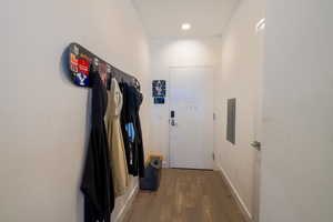 Doorway with wood finished floors, recessed lighting, and electric panel