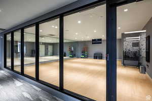 Doorway with wood finished floors and recessed lighting