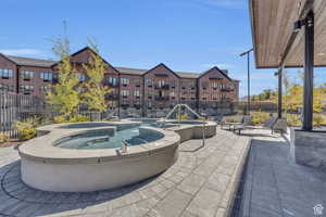 View of patio with a pool with connected hot tub