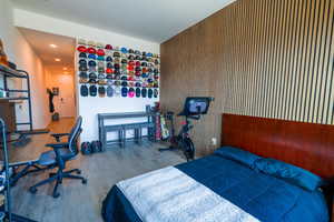 Bedroom featuring wood finished floors, wood walls, and recessed lighting