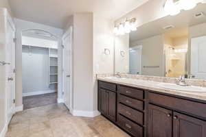 Primary bathroom with double vanity and walk-in closet