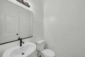 Half bathroom featuring a sink and toilet