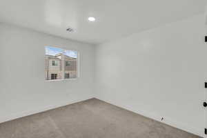 Carpeted empty room with baseboards and a textured ceiling