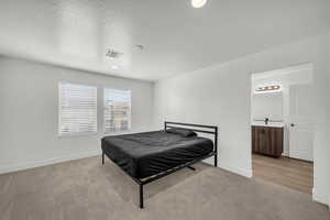Bedroom featuring light carpet, a textured ceiling, and recessed lighting