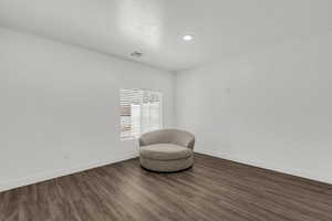 Living area featuring dark wood-type flooring and a textured ceiling