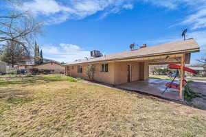 Back of house with brick siding and a yard