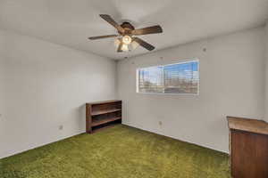Empty room with a textured ceiling, carpet floors, and a ceiling fan