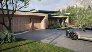 View of side of property with driveway, an attached garage, and a mountain view