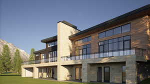 Back of property with a yard, a balcony, and a mountain view
