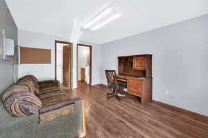 Office space with dark wood-type flooring and baseboards