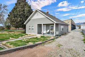 View of front facade featuring a porch, a chimney, board and batten siding, a shingled roof, and a mountain view