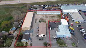 Aerial view of property and surrounding area featuring property parcel outlined and an industrial area