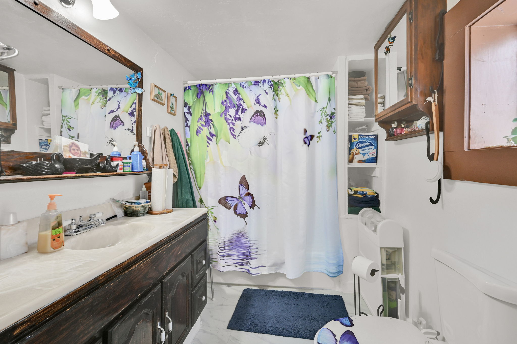 Full bathroom featuring vanity, shower / bath combination with curtain, and light marble finish flooring