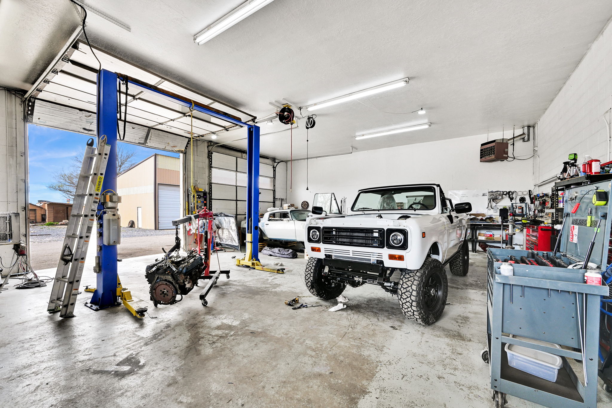 Garage featuring a heating unit and a workshop area