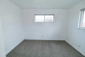 Carpeted spare room with baseboards