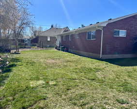 Rear view of house with brick siding and a lawn