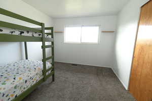 Bedroom featuring carpet flooring and baseboards