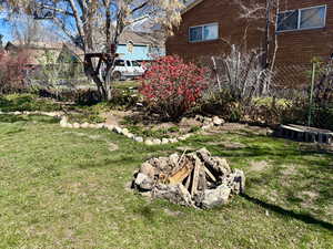 View of green lawn featuring a fire pit