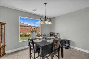 Dining area featuring a chandelier and light tile patterned flooring