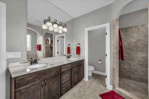 Full bathroom with double vanity, a walk in shower, and light tile patterned floors