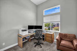 Office area featuring dark carpet and baseboards