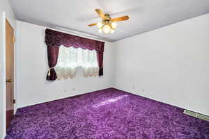 Spare room with ceiling fan and carpet flooring