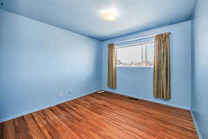 Empty room with wood finished floors and baseboards