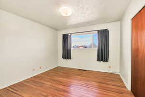 Spare room featuring wood finished floors and baseboards