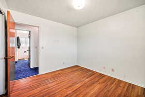 Unfurnished room with wood finished floors and baseboards
