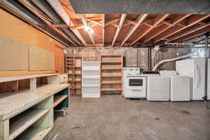 Unfinished below grade area with freestanding refrigerator and independent washer and dryer