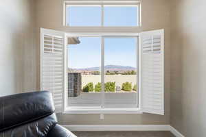Sitting room with carpet flooring, a mountain view, and healthy amount of natural light