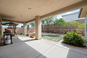 Fenced backyard featuring a patio and grilling area