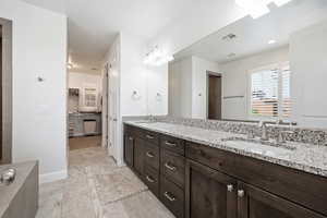 Full bathroom with double vanity and a spacious closet
