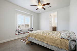 Bedroom featuring carpet, ceiling fan, and ensuite bath