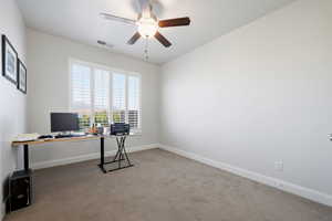 Office area with light carpet and a ceiling fan