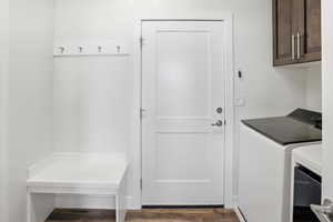 Laundry room featuring independent washer and dryer and dark wood-style floors