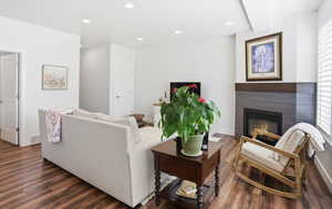 Living room featuring recessed lighting, dark wood-style floors, and a tiled fireplace