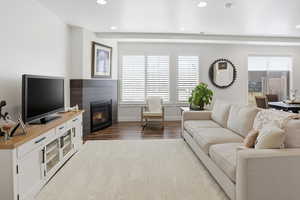 Living room featuring a fireplace, recessed lighting, and dark wood-style flooring