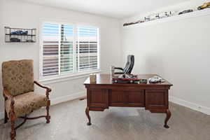 Home office with carpet flooring and baseboards