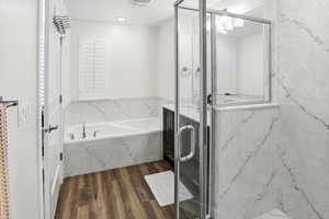Bathroom with vanity, a marble finish shower, dark wood-style floors, and a bath