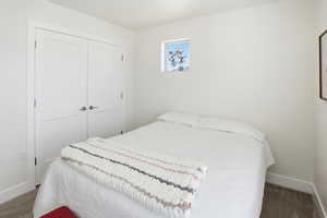 Carpeted bedroom with baseboards and a closet